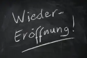 Wiedereroeffnung means reopening in German - handwritten text on chalkboard