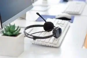 Hotline operator's desk with computer keyboard and modern headset at call centre